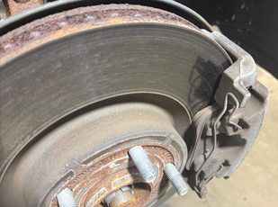 Brake inspection with wheel removed showing rotor and caliper