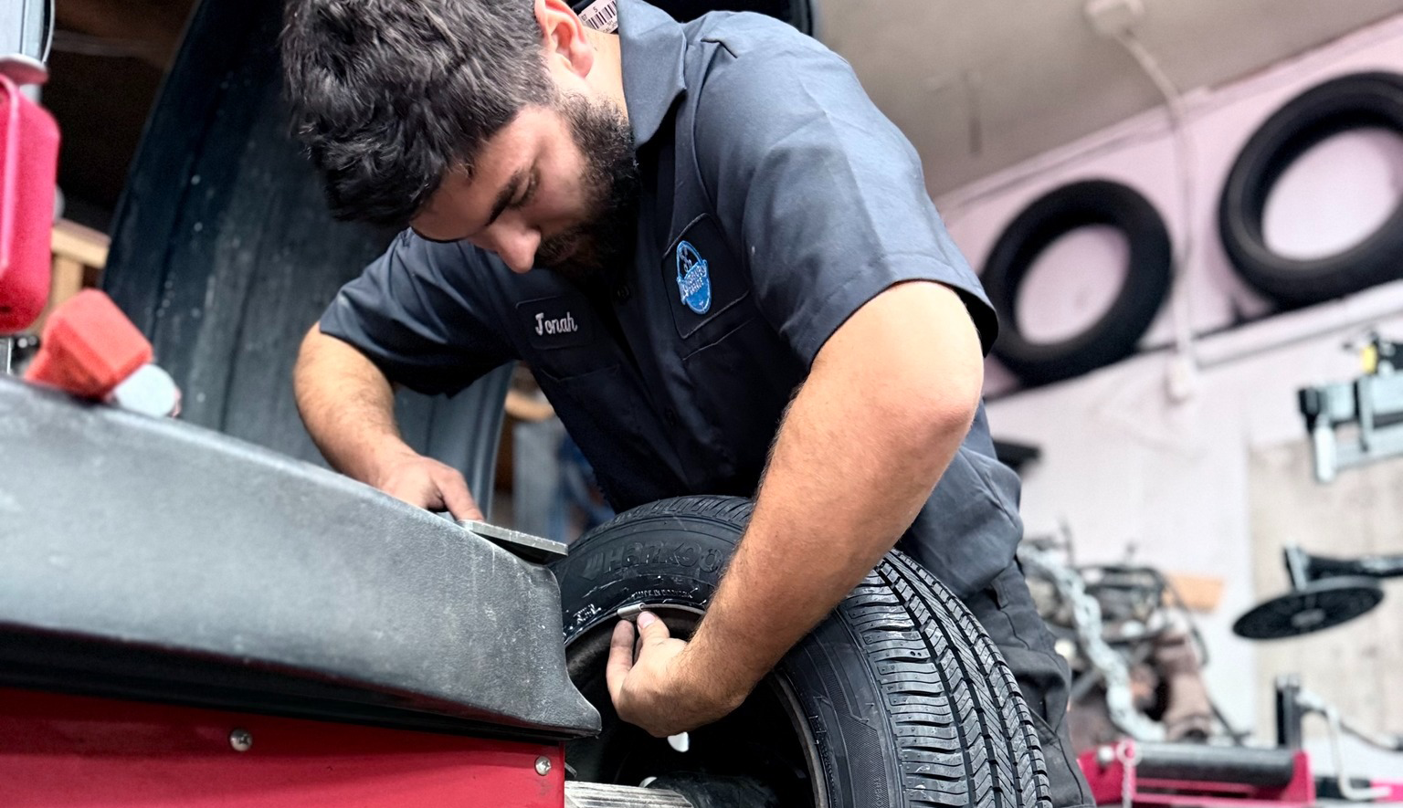 Technician performing tire repair and mounting on a wheel